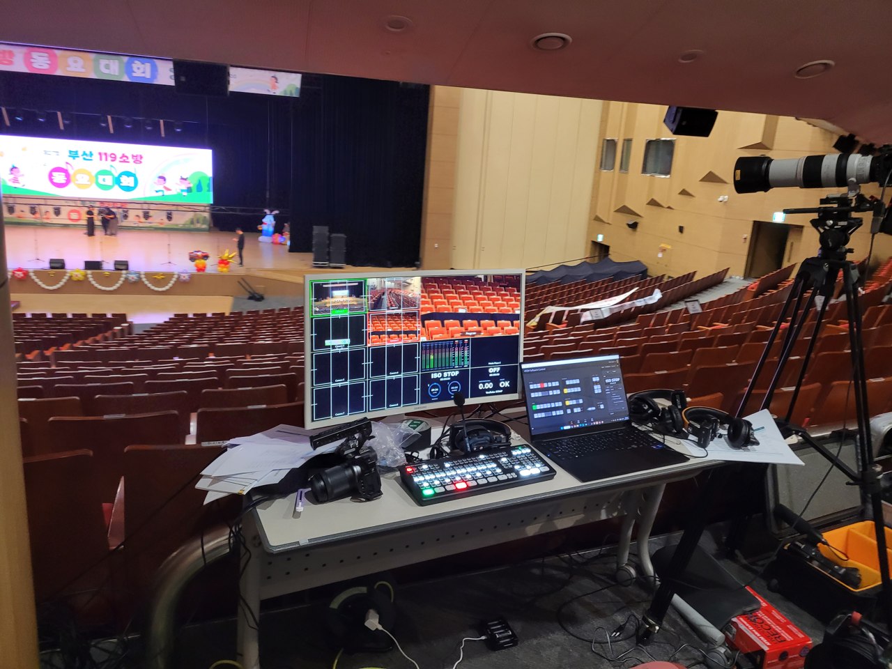 객석 뒤편에 설치된 중계 모니터와 영상 전환 장비, 촬영 카메라