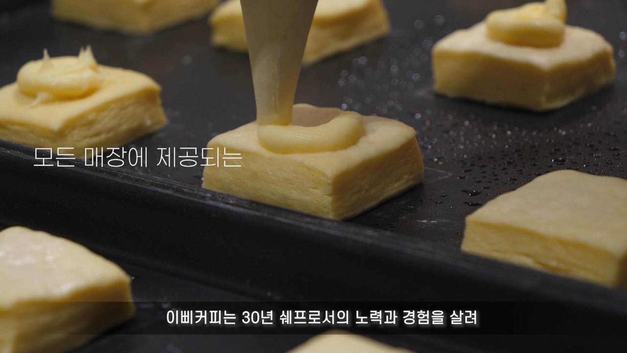반죽 위에 크림을 채우는 제조 과정의 근접 촬영 장면